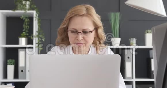 微笑的女商人在笔记本电脑上工作视频的预览图