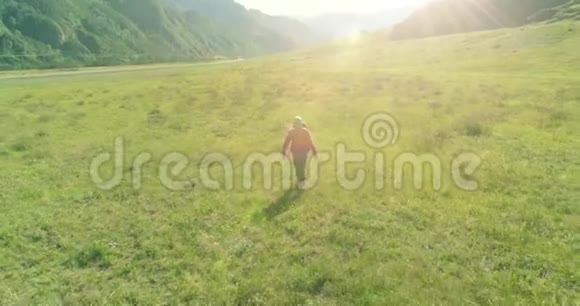 飞行背包徒步旅行游客走过青山野夏日的乡村山谷视频的预览图