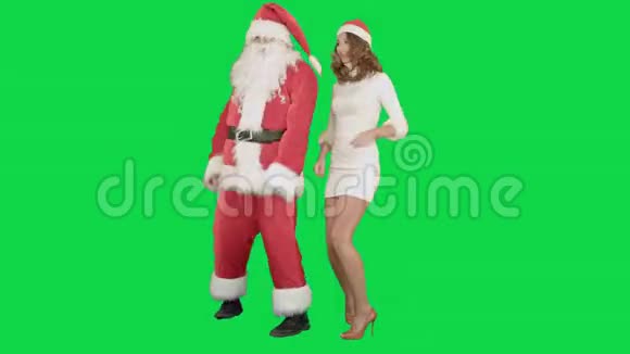 圣诞女孩和圣诞老人在绿茵上跳舞视频的预览图