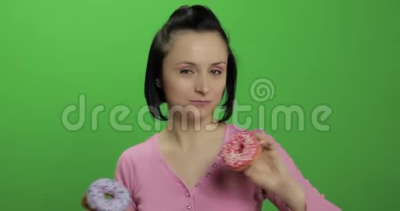 快乐美丽的女孩摆姿势玩甜甜圈铬键视频的预览图