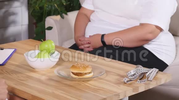 胖女人在苹果和汉堡之间选择饮食和健康视频的预览图