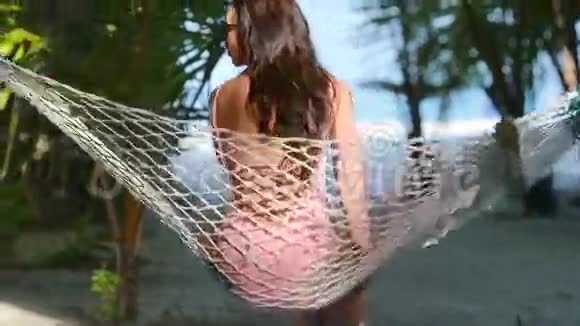 热带海滩吊床上放松的美丽女人视频的预览图