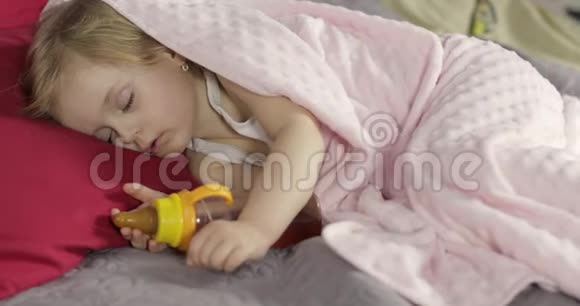 可爱的婴儿睡在家里的床上小女孩睡在晨光里视频的预览图