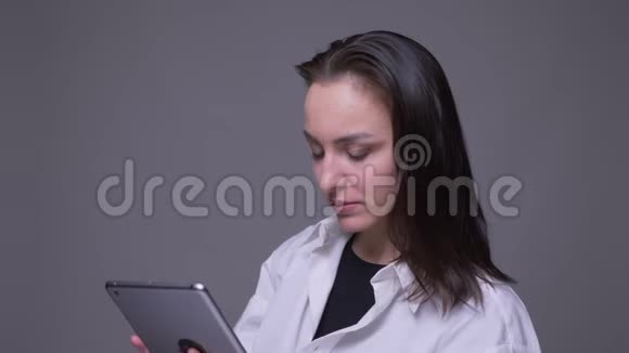 在镜头前的平板电脑上发短信的白种人成年女性的特写肖像背景视频的预览图