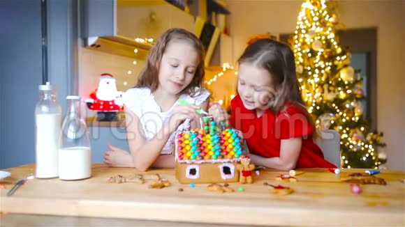小女孩在装饰好的客厅壁炉前做圣诞姜饼屋视频的预览图