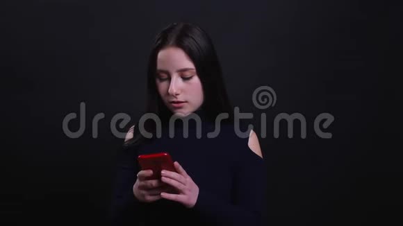 年轻漂亮的深色头发女性的特写镜头在镜头前用手机拍摄背景视频的预览图