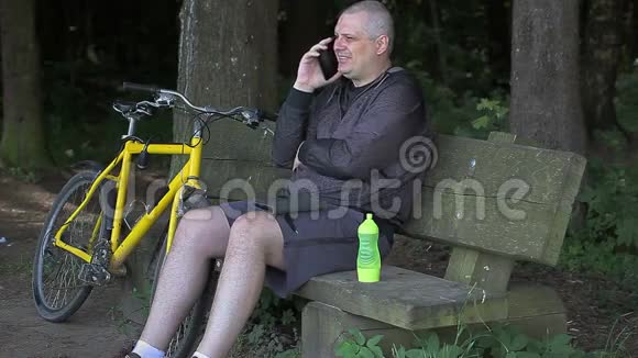 公园里骑自行车的人用手机说话视频的预览图