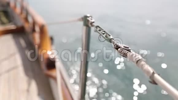 一艘木制古董帆船在阳光明媚的海洋中航行甲板上的特写显示了木制部件和视频的预览图