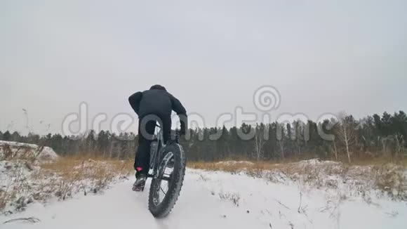 专业的极限运动员骑自行车在户外骑胖自行车后轮的近距离观察冬天骑自行车视频的预览图