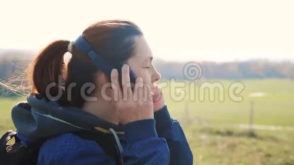 中年女性游客带着背包的生活方式在耳机里听音乐看着智能手机里视频的预览图