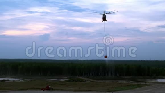 悬挂式溢流钢包的货运消防直升机正从水库飞来视频的预览图