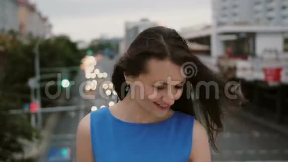 风吹长黑发美丽的年轻女人快乐微笑的女孩站在桥上看着相机4K视频的预览图