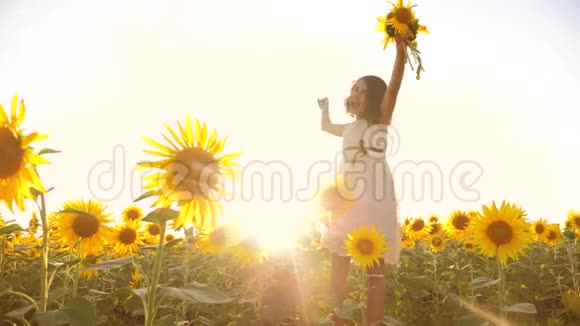 可爱的女孩在黄色的花园向日葵生活方式阳光在夏天美丽的日落小女孩向日葵视频的预览图