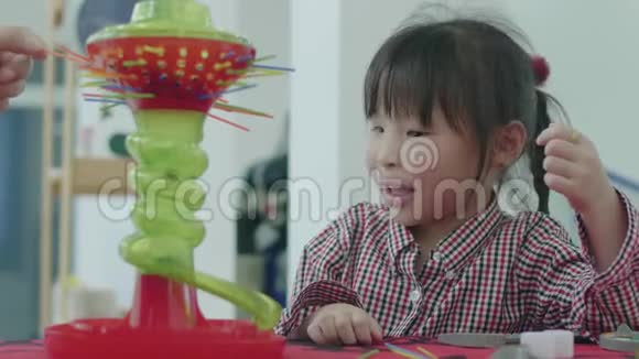 可爱的亚洲小女孩在家和妈妈玩视频的预览图