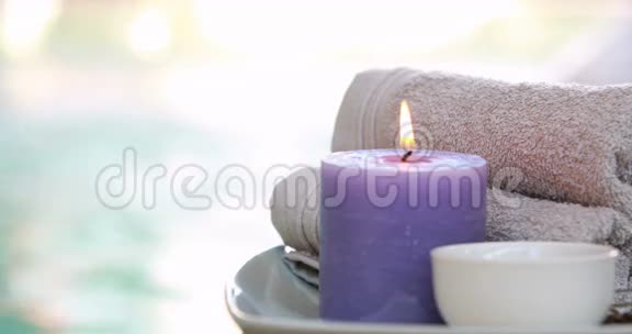 用蜡烛在盘子上呈现的碗的美容治疗视频的预览图