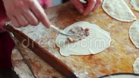 女人准备肉馅饼用面团和馅特写视频的预览图