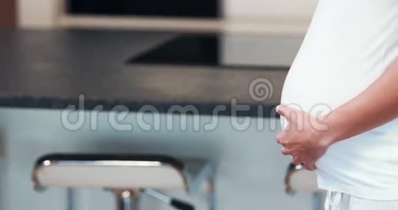 厨房里喝橙汁的孕妇视频的预览图