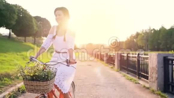 日落时骑自行车的年轻美女视频的预览图
