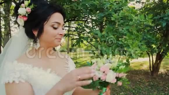 公园里有结婚花束的漂亮新娘视频的预览图