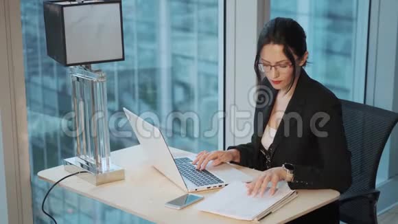 一位年轻的女商人在现代办公室的电脑上工作的画像视频的预览图
