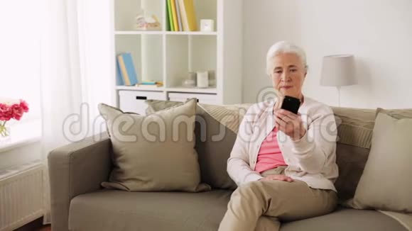 有智能手机的高级女性在家自拍视频的预览图