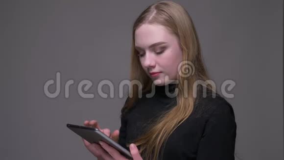 年轻漂亮的深色头发的女性使用平板电脑特写肖像并显示绿色彩色屏幕与相机视频的预览图