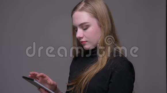 用平板电脑为年轻漂亮的黑发女性拍摄特写肖像并将绿色屏幕显示到背景相机上视频的预览图