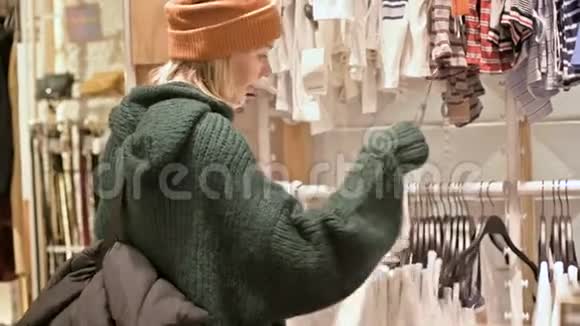 一个穿着绿色毛衣和黄色帽子的女孩穿过一家商店选择买什么把事情搞得一团糟视频的预览图
