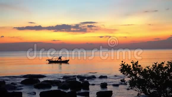 日落时分与渔夫一起的小船的剪影船在公海日落地平线上美丽的黄色视频的预览图