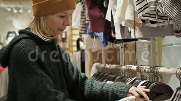 一个穿着绿色毛衣和黄色帽子的女孩穿过一家商店选择买什么把事情搞得一团糟视频的预览图