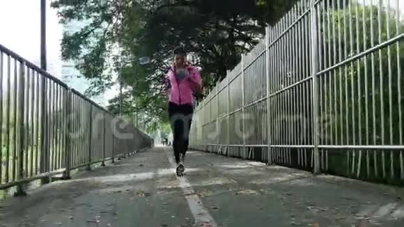 早上在人行道上奔跑的年轻亚洲女人视频的预览图