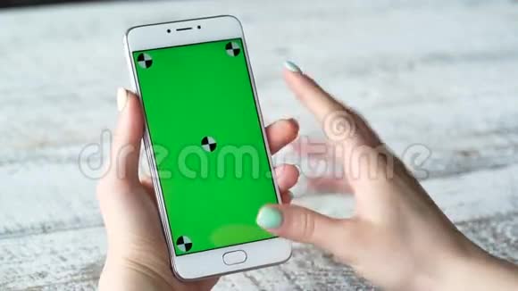 年轻女性使用绿色屏幕智能手机视频的预览图