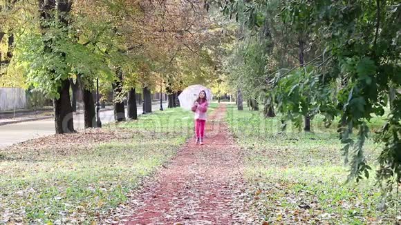 带着雨伞在公园散步的小女孩视频的预览图