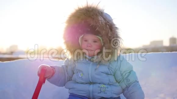 在阳光明媚的日子里快乐的孩子在冬天的公园里开心地笑着冬天的雪景户外视频的预览图