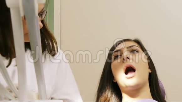 与一名年轻女性病人在牙科诊所工作的牙医视频的预览图