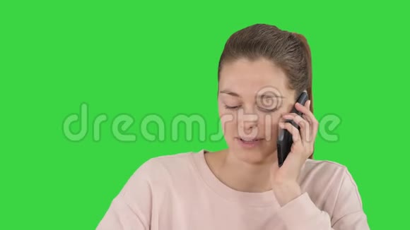 美丽的女人在绿色屏幕上的手机上交谈Chroma键视频的预览图