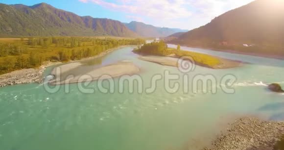 在阳光明媚的夏季早晨低空飞行在带岩石的新鲜快山河上视频的预览图