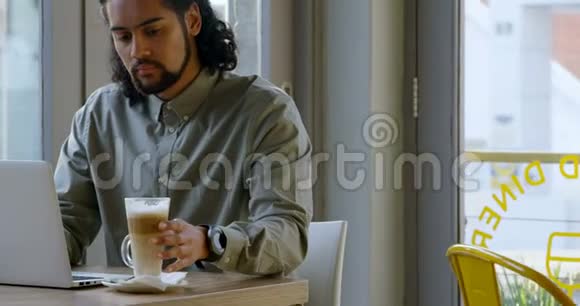 行政人员在使用4k笔记本电脑时喝咖啡视频的预览图
