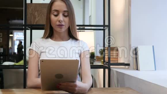 年轻女孩在工作中使用平板电脑视频的预览图