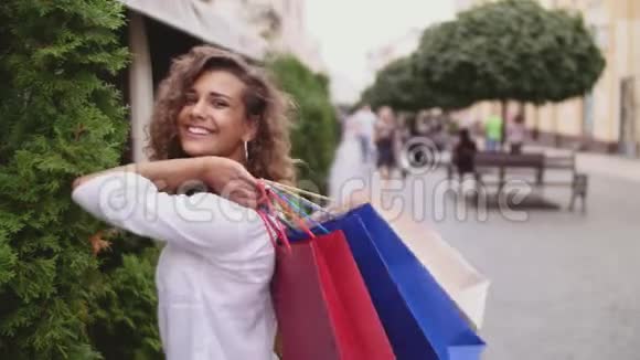 美丽的女人拿着购物袋微笑着户外视频的预览图