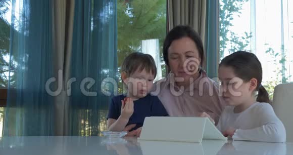 奶奶用平板电脑游戏招待她的小孙子们视频的预览图