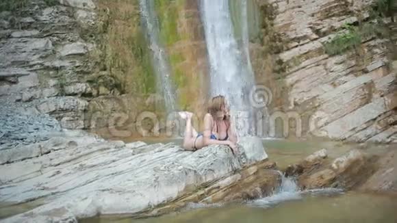 穿比基尼的女孩在瀑布里洗澡视频的预览图
