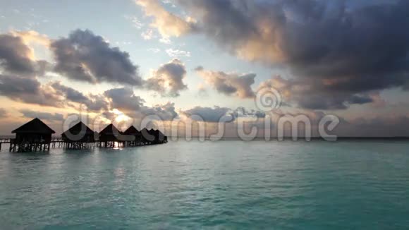 马尔代夫日落时房子成堆在水面上视频的预览图