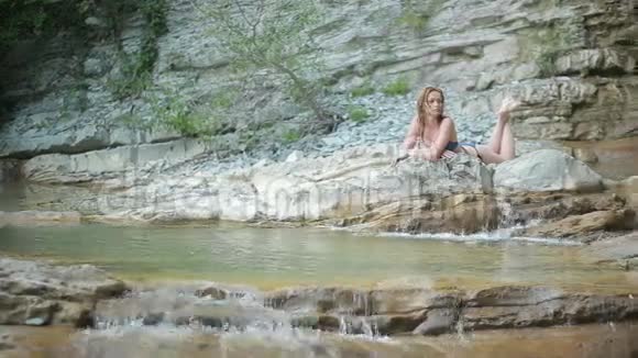 穿比基尼的女孩在瀑布里洗澡视频的预览图