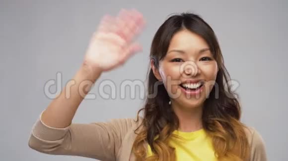 微笑的亚洲女人挥手视频的预览图