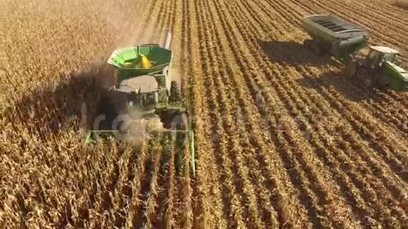 4k无人驾驶飞机观看大型农业联合卡车机器车辆收割农作物农田有机小麦视频的预览图