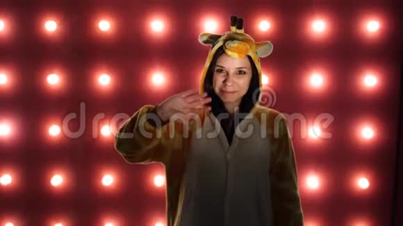 长颈鹿的睡衣橙色背景下女人的情感肖像一个疯狂有趣的女人视频的预览图