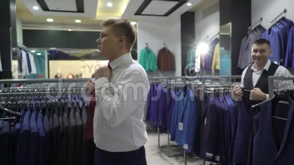 购物和时尚理念年轻人在商场或服装店挑选和试穿夹克视频的预览图