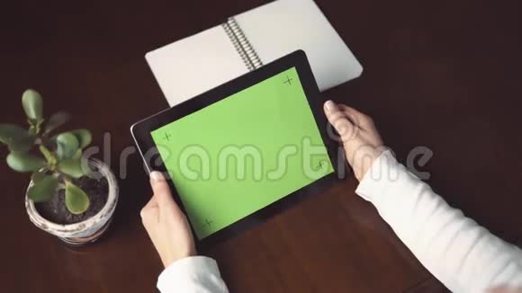 妇女持有平板电脑与绿色屏幕视频的预览图