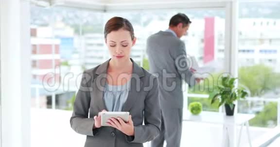 女商人用平板电脑和她的同事视频的预览图